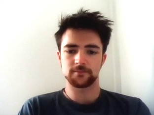 Handsome man is relaxing within doors and shooting himself on web cam